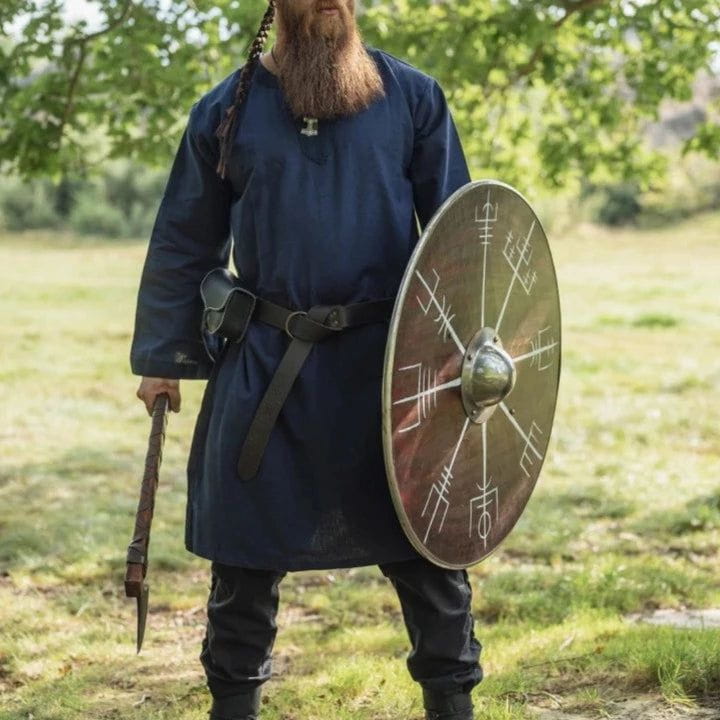 Man in a blue cotton Renaissance tunic, holding an axe and shield.