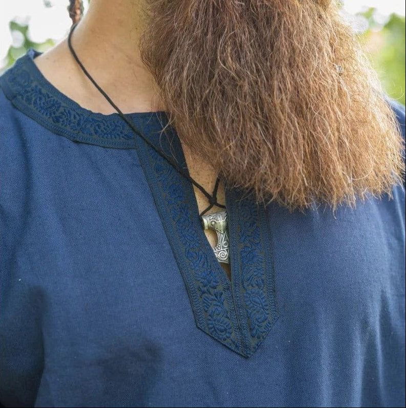 Blue cotton Renaissance tunic with embroidered trim and a silver pendant.