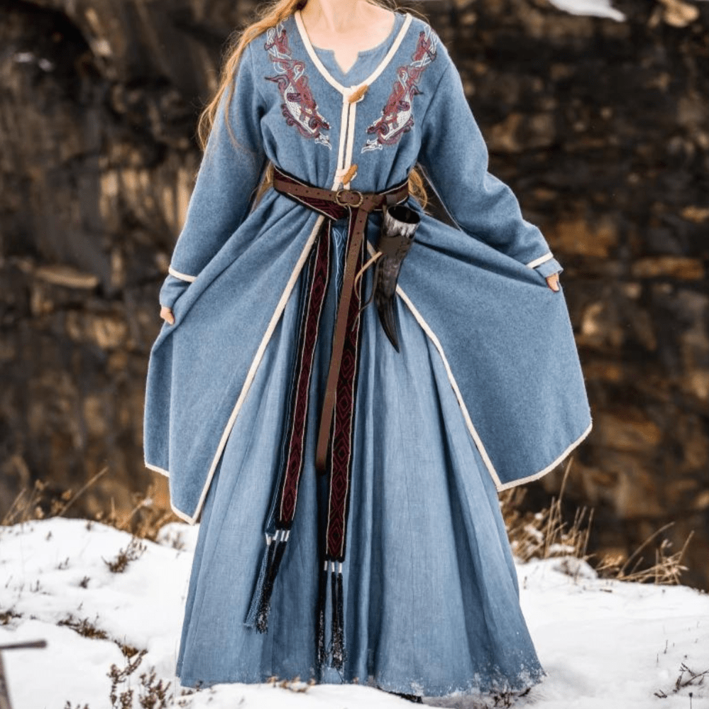 Blue Renaissance wool coat with hand embroidery, cream trim, and wooden toggle closures.