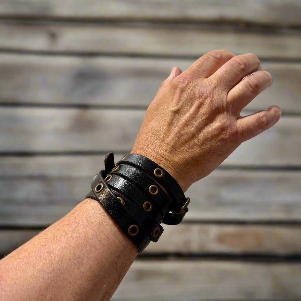 Brown leather Renaissance wrap bracelet with brass hardware and adjustable buckle on a wrist.