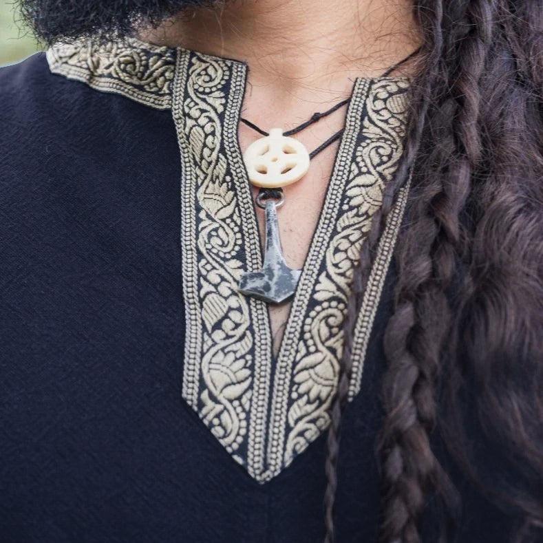 Dark blue Renaissance cotton tunic with gold embroidered V-neckline, featuring a bone and metal pendant.