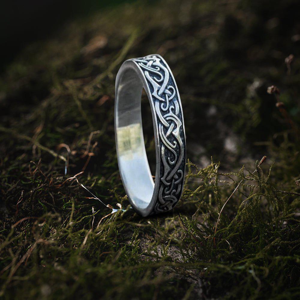 Sterling silver Renaissance ornament ring with intricate Celtic knotwork design on moss.