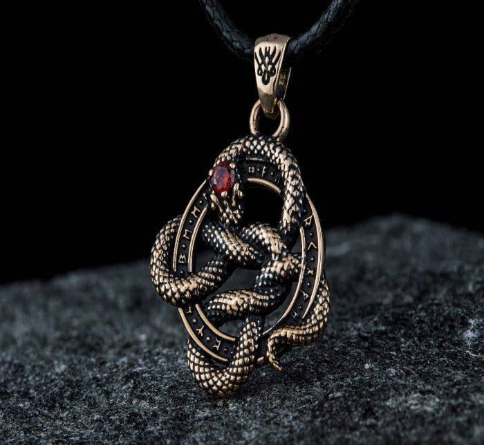 Renaissance bronze snake pendant with runic engravings and a red cubic zirconia eye, on a black cord.