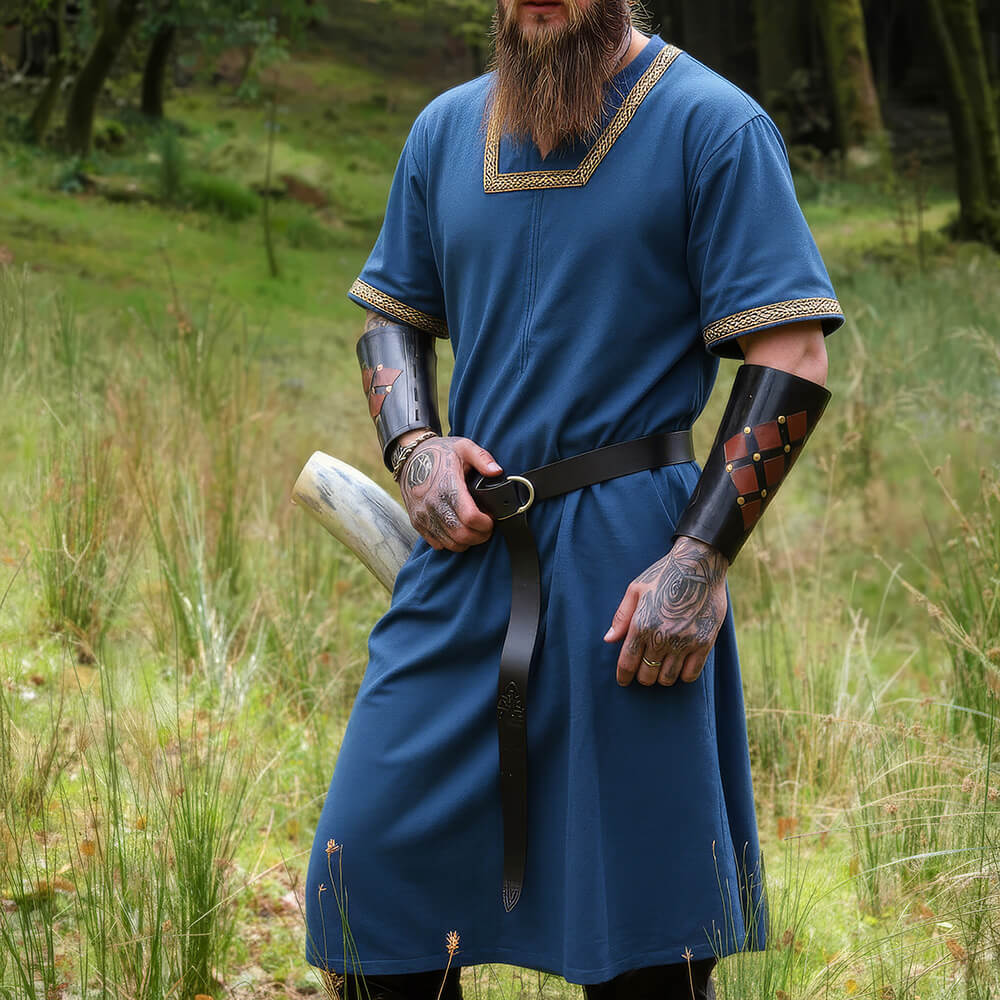 Blue short-sleeved Renaissance tunic with gold embroidery, worn with a black leather belt and bracers.