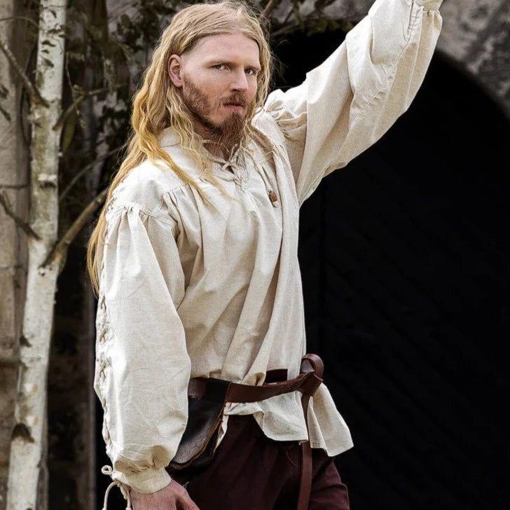 Man in natural Renaissance stand-collar shirt with adjustable tie sleeves and brown leather belt.