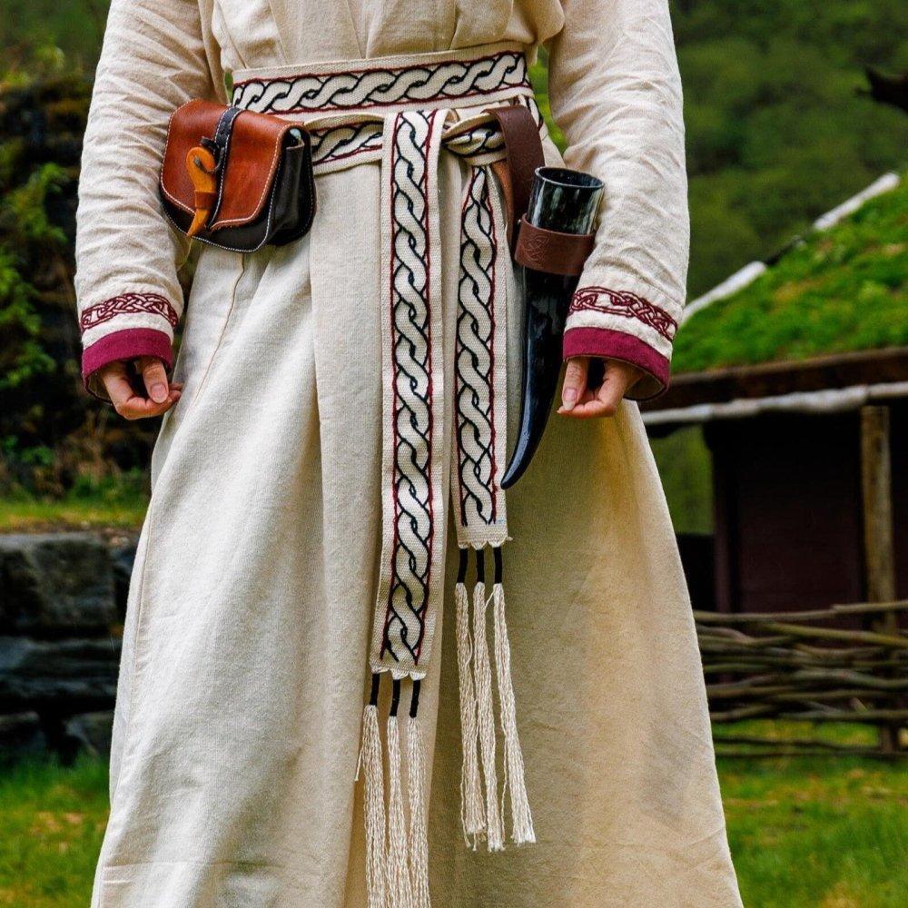 Renaissance woven tie belt in natural cotton with red accents, worn over a cream dress.