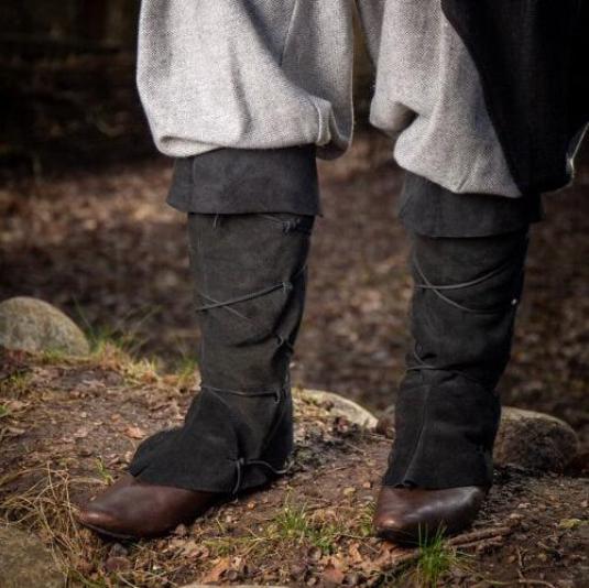 Dark brown suede Renaissance gaiters with leather lacing over brown shoes, covering the lower legs.