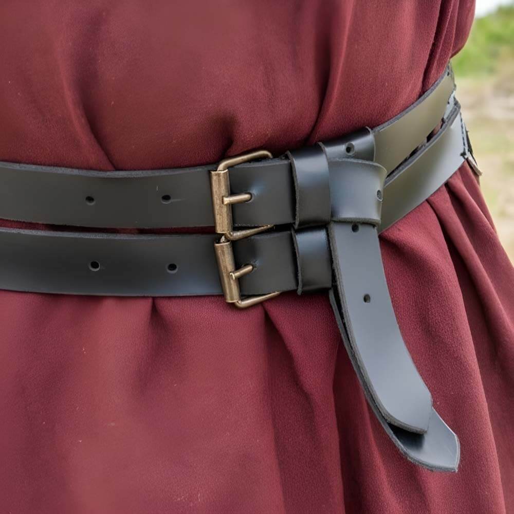 Black faux leather Renaissance twin belt with brass buckles, worn over a red tunic.