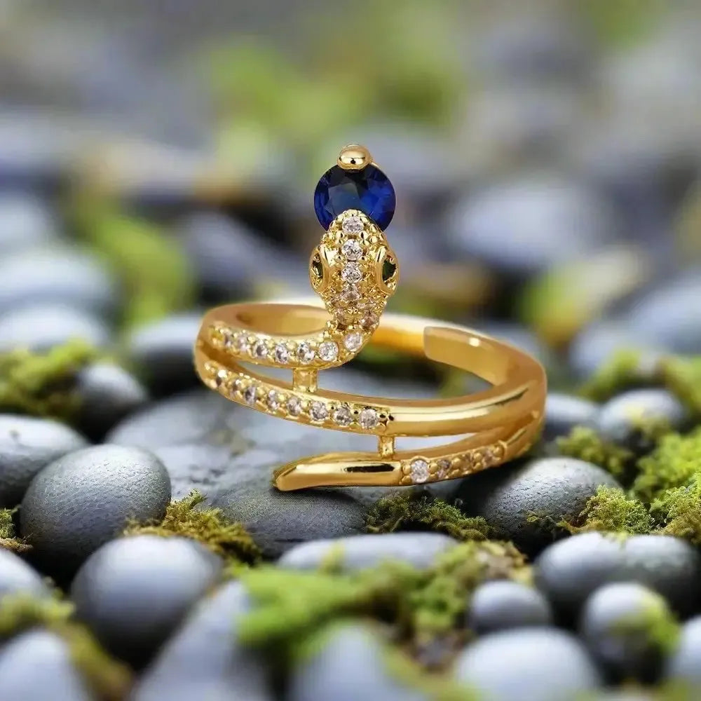 Gold Renaissance serpent ring with a blue gemstone and inlaid zircon detailing.