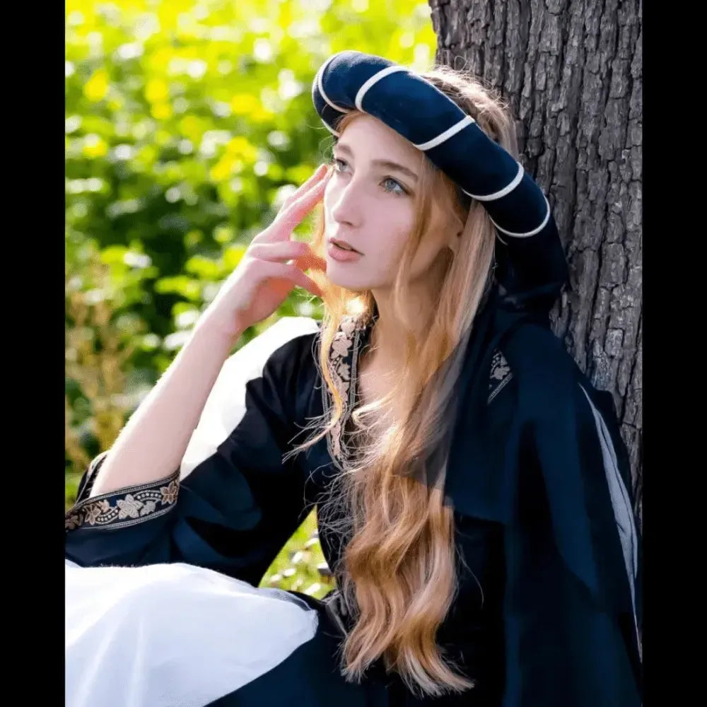 Elegant Renaissance headdress: black and gold striped chaplet with a delicate veil, worn by a woman.