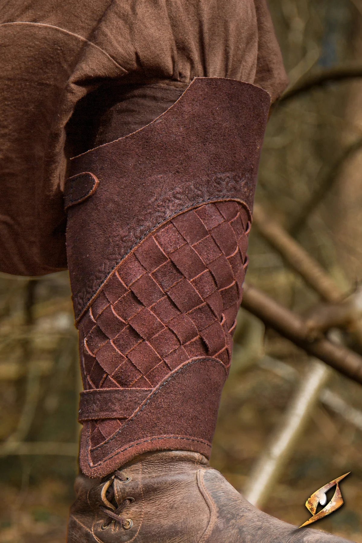 Renaissance brown woven leather greave with lamellar design and brass buckle.
