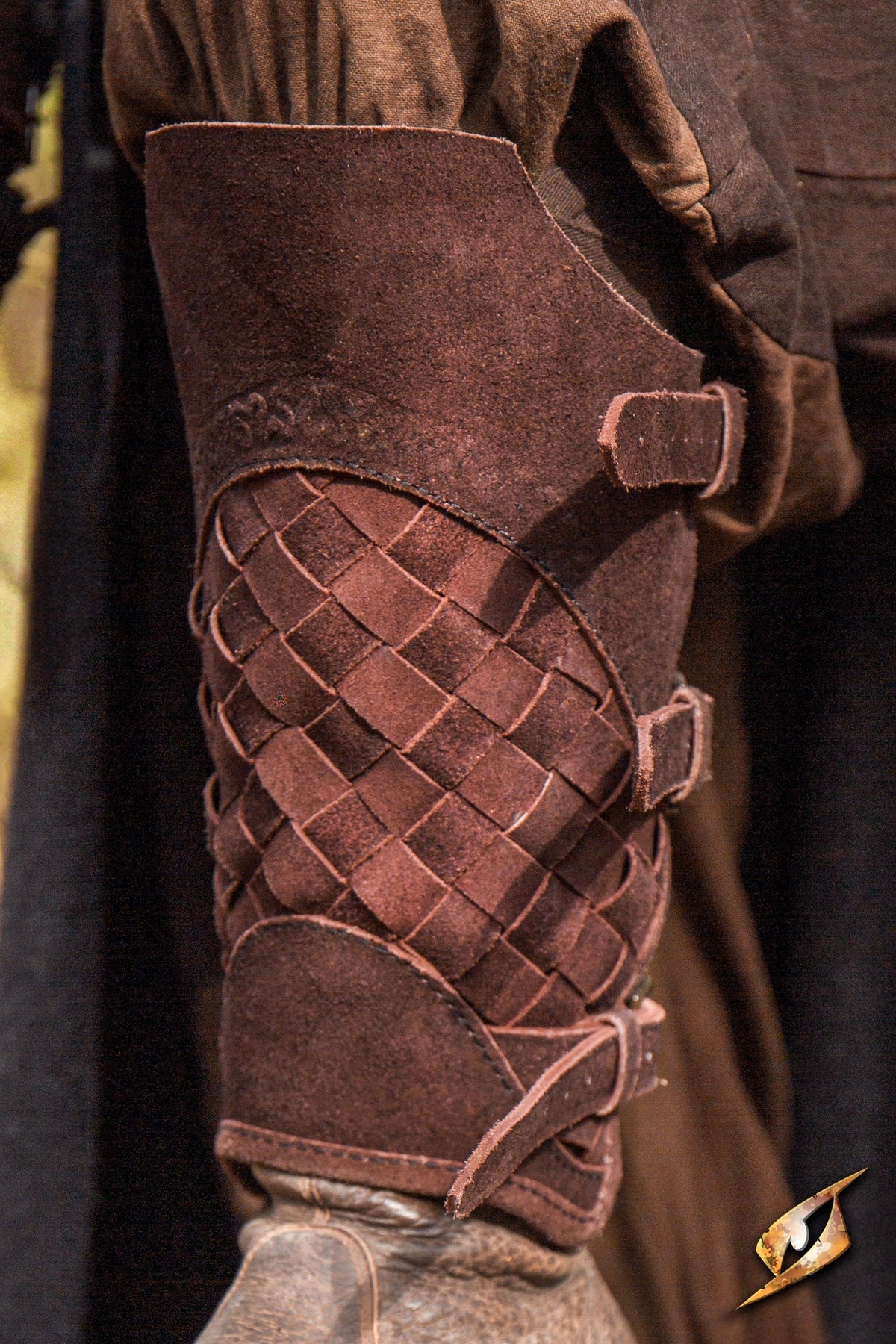 Brown Renaissance woven leather greave with brass buckles, inspired by lamellar armor.