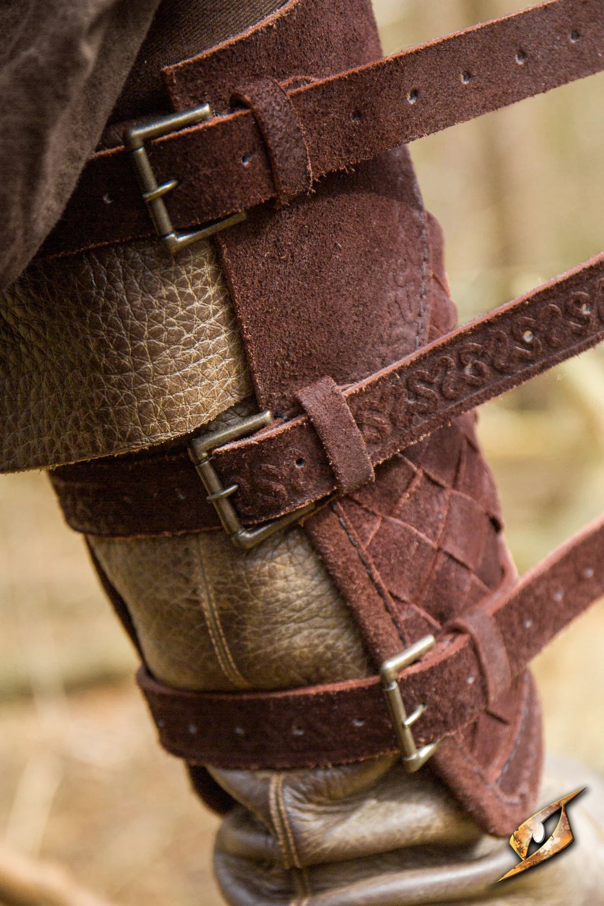 Renaissance brown woven leather greaves with brass buckles, inspired by lamellar armor.