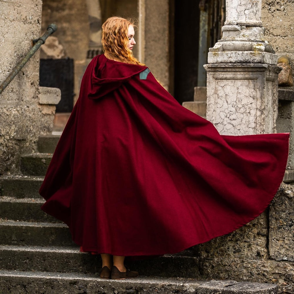 Close-up of red wool cloak fabric and hood edge