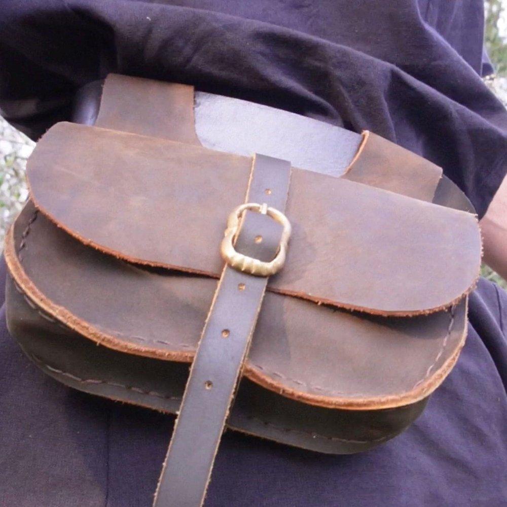 Renaissance brown full-grain leather belt pouch with a secure buckle closure, attached to a dark garment.