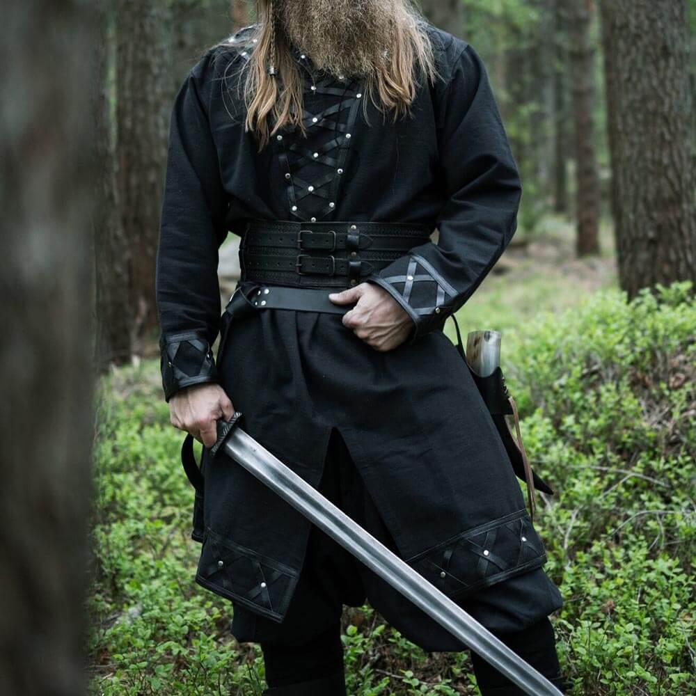 Black Renaissance long-sleeve tunic with genuine leather accents and a sword in a forest setting.