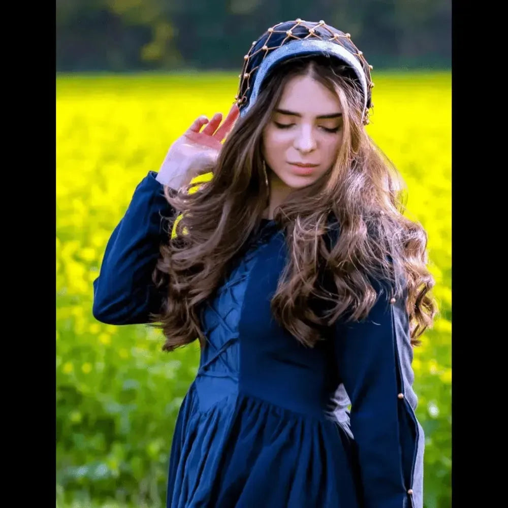 Renaissance black velvet headwear with elegant beaded drapery on a woman in a field of yellow flowers.