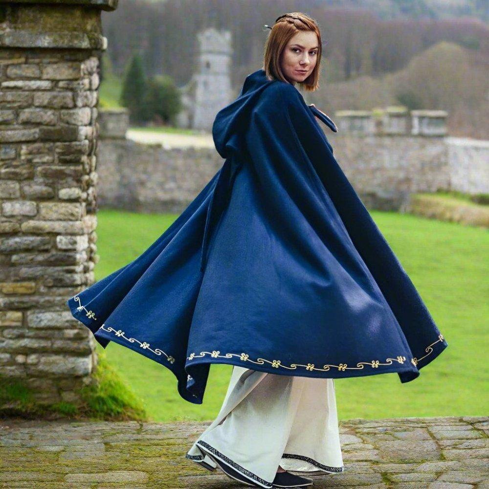 Blue Renaissance hooded wool blend cloak with unique gold hand embroidery, flowing over white period garments.