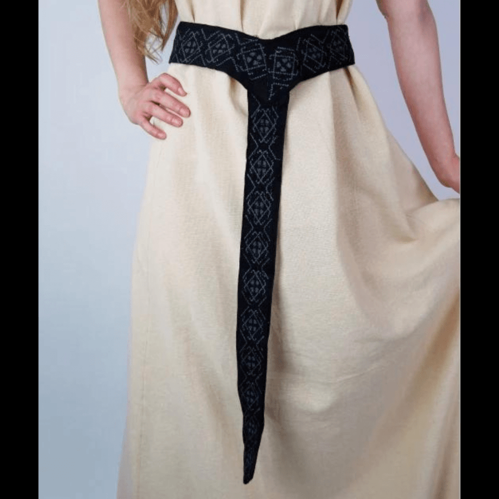 Black Renaissance embroidered cotton fabric belt with geometric patterns, worn over a cream dress.