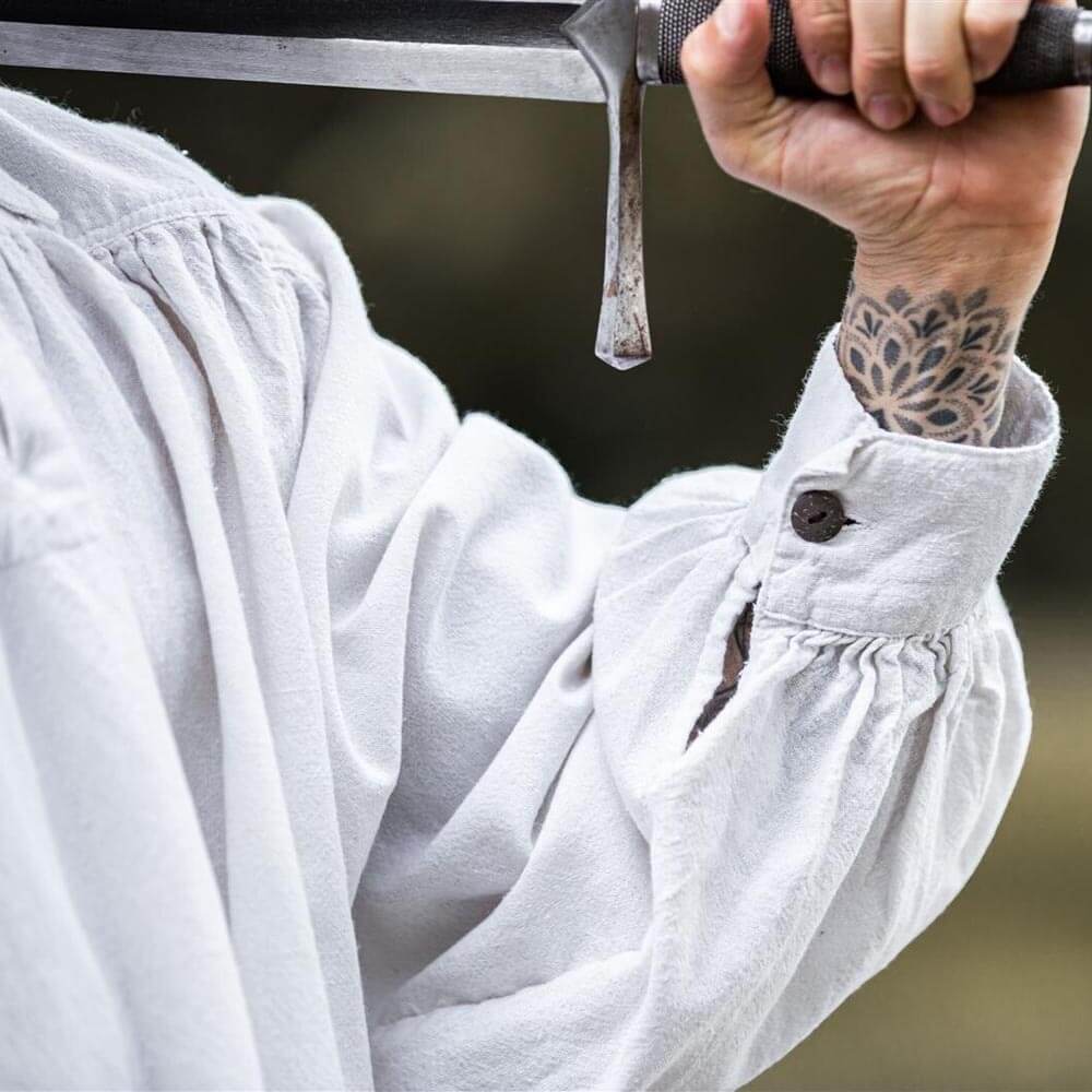 White Renaissance cotton shirt with ample fit, gathered sleeves, and a wooden cuff button.
