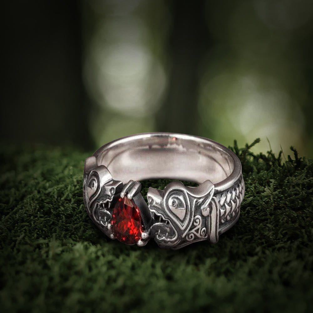 Sterling silver Fenrir Wolf Renaissance ring with a red gemstone, on moss.