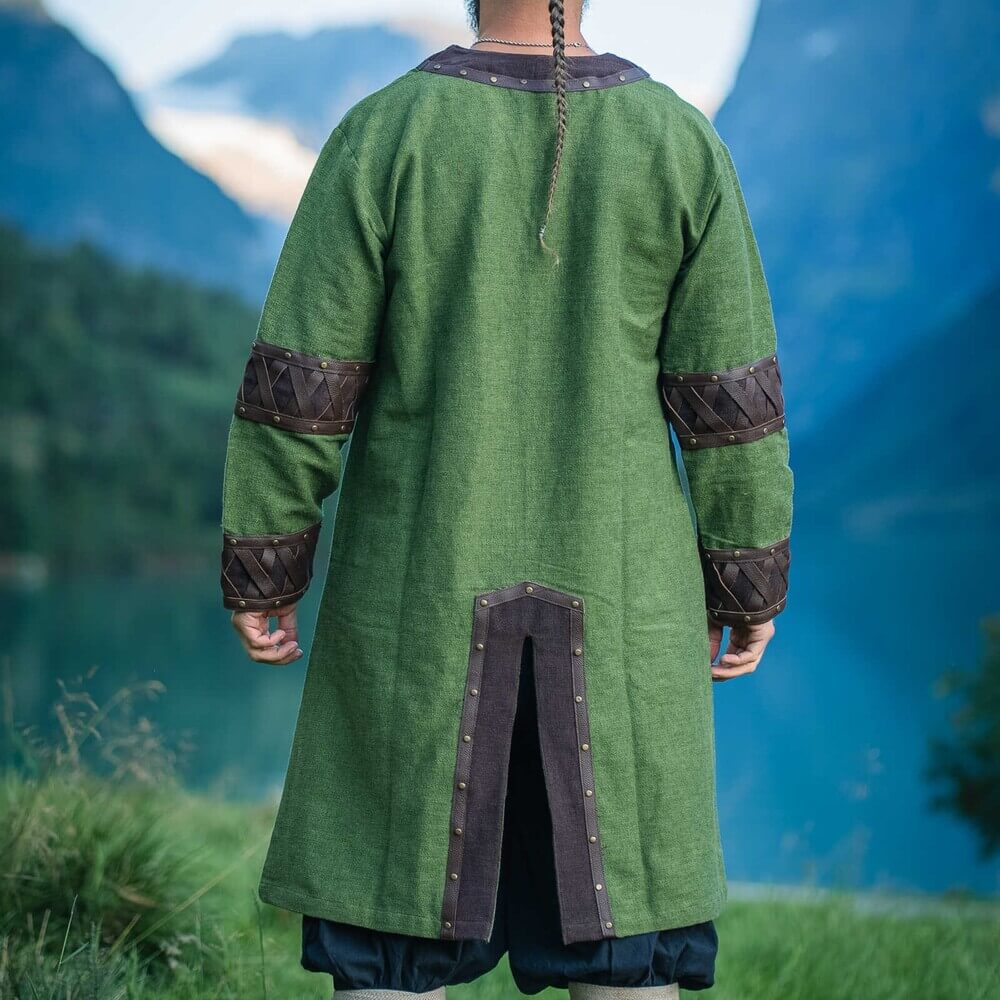 Renaissance green tunic with ornate leather trim, X-pattern cuffs, and front slit, seen from the back.