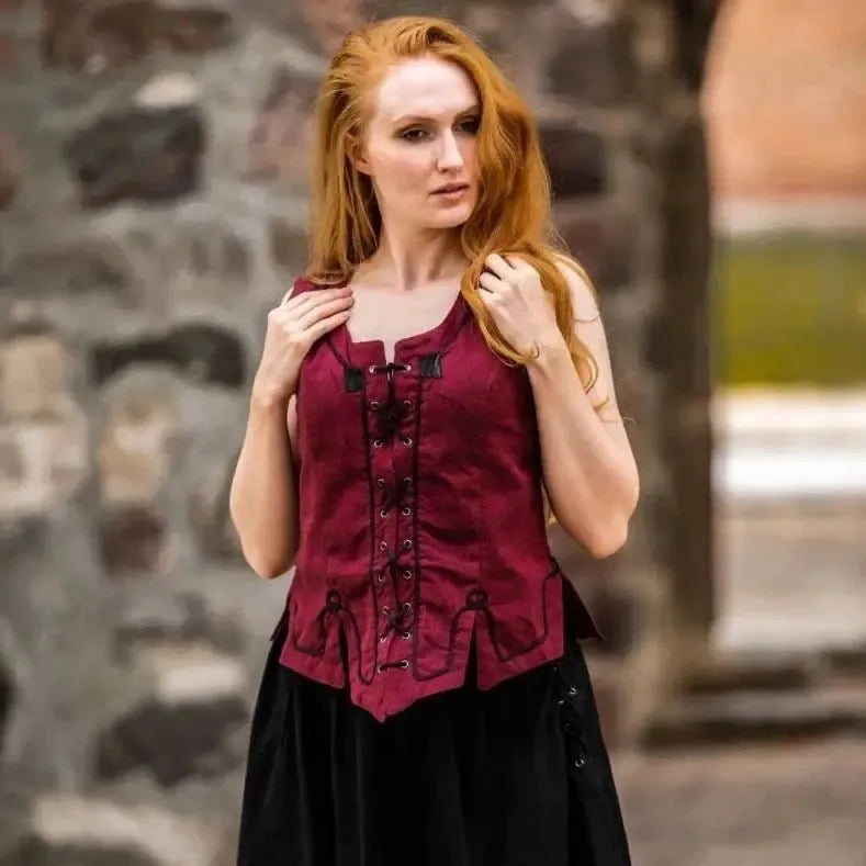 Renaissance red cotton bodice with front lacing and embroidery, worn by a woman.