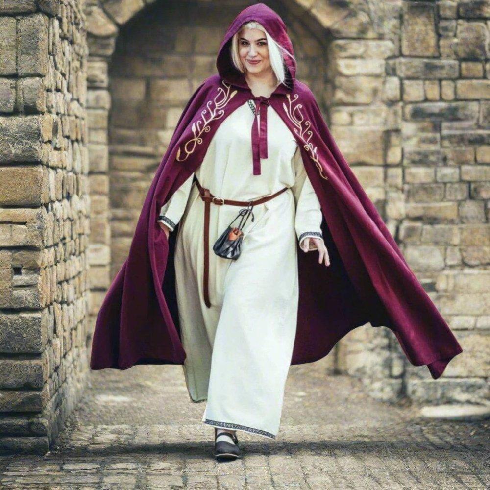 Renaissance cloak with hood, red cotton, gold embroidery, worn by a woman in a stone archway.