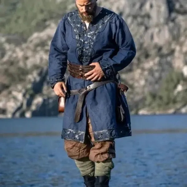 Renaissance blue cotton tunic with intricate silver embroidery, worn by a man with a leather belt.