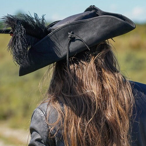 Black Renaissance leather tricorn hat with feathers, worn by a person with long brown hair.
