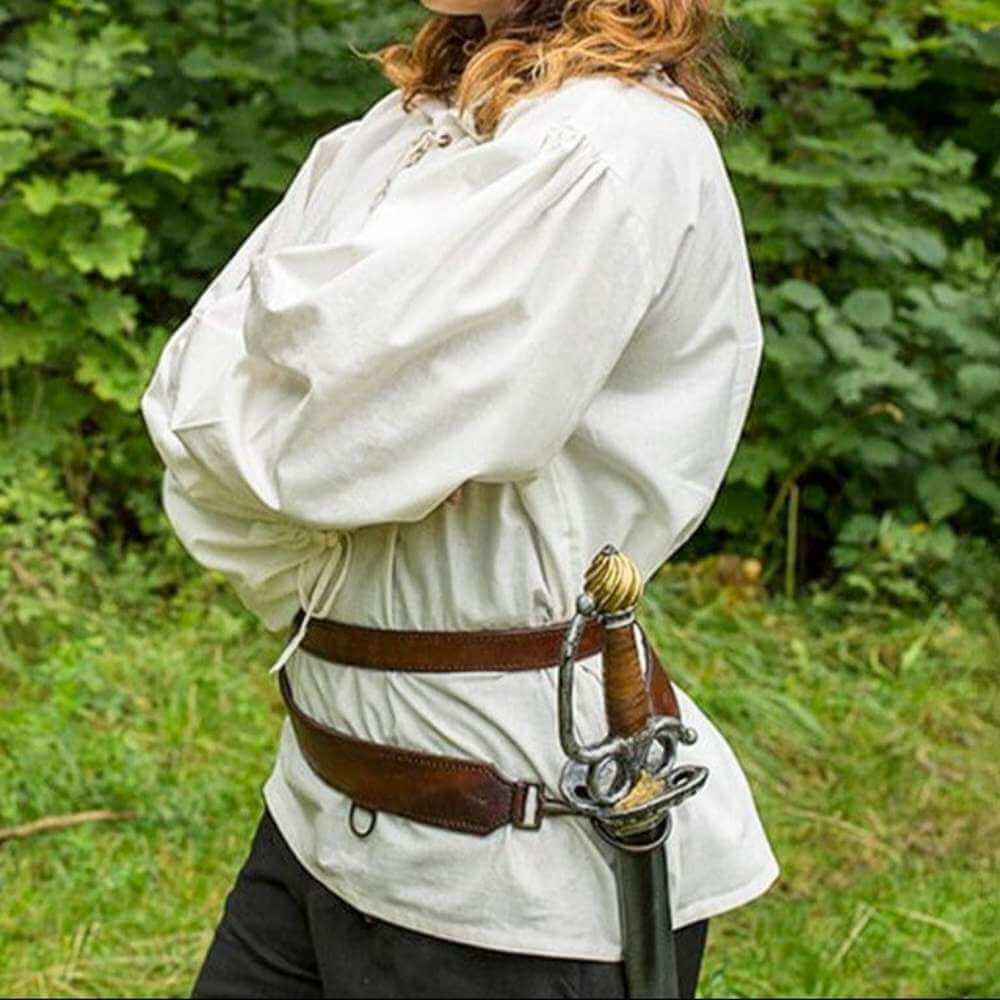 Renaissance black leather sword belt with brass buckles, worn over a white shirt, holding a sword.
