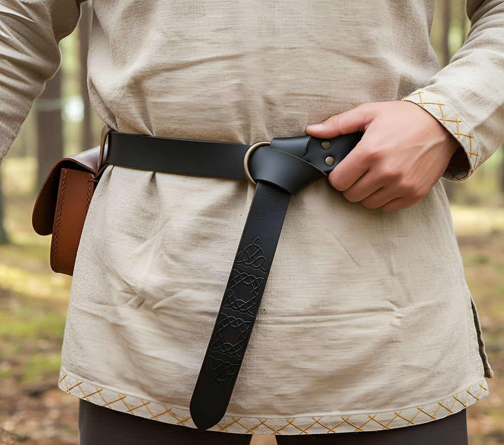 Black full-grain leather Renaissance belt with a ring loop and Celtic knotwork design, worn over a tunic.