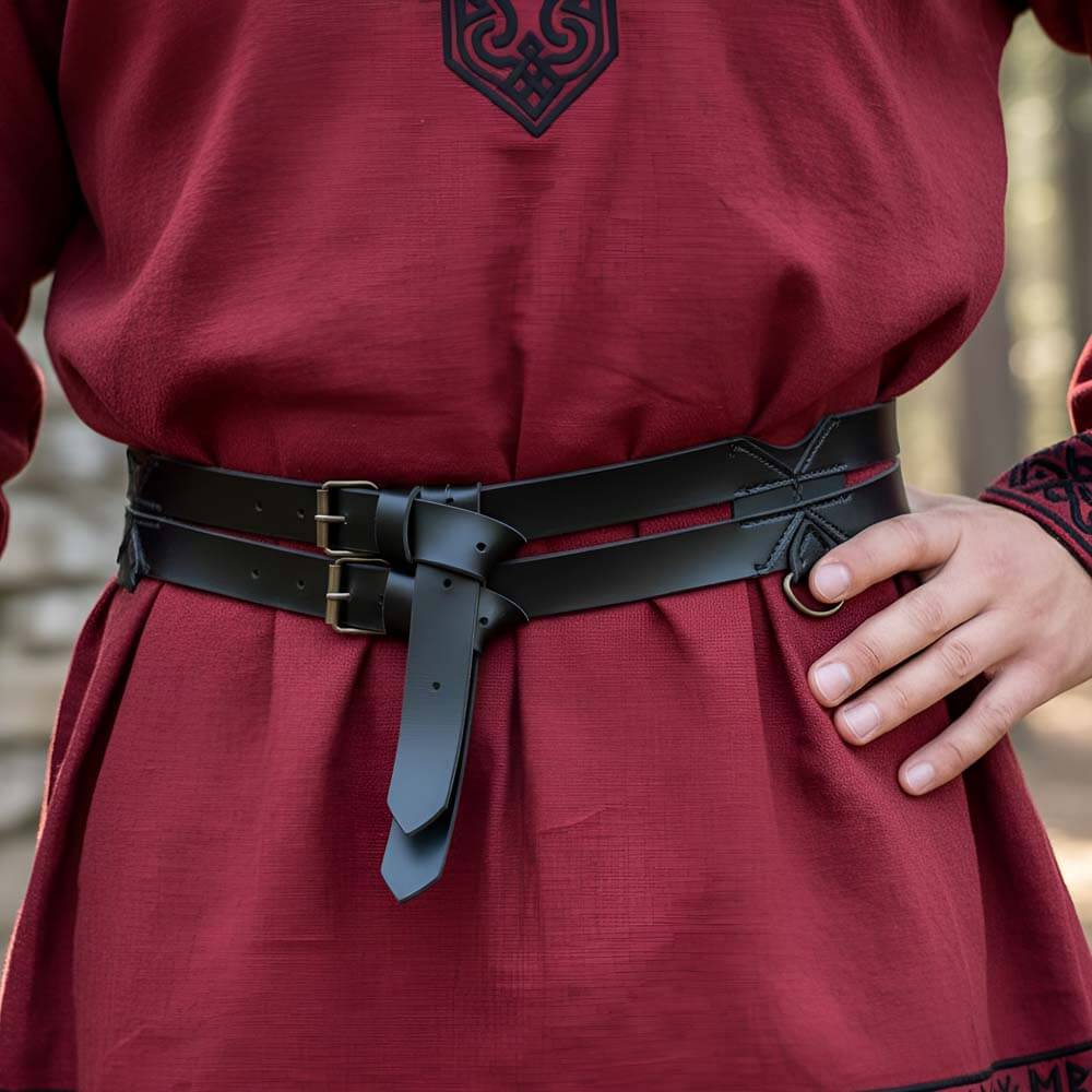 Black faux leather Renaissance twin weapons belt with brass D-rings and buckles, worn over a red tunic.