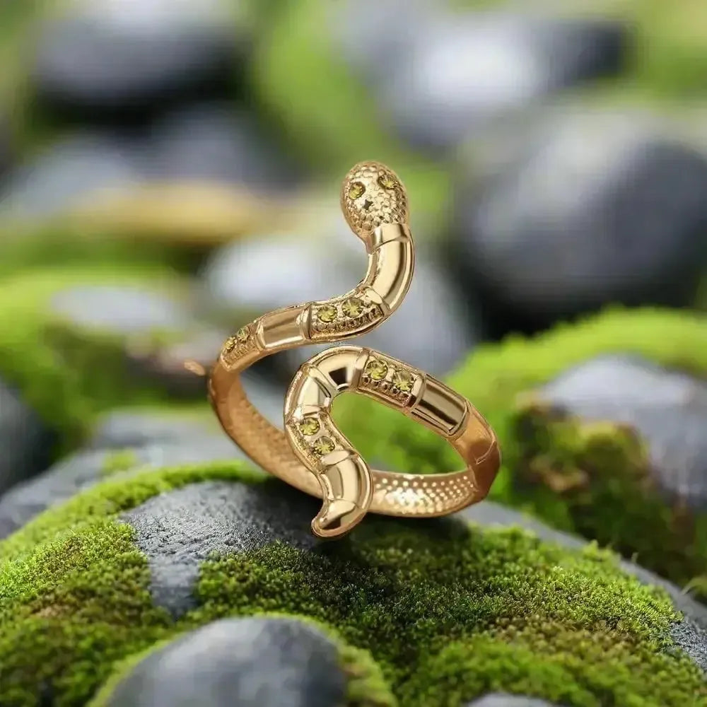 Renaissance gold snake ring with double green gemstone inlay and detailed snakeskin texture.