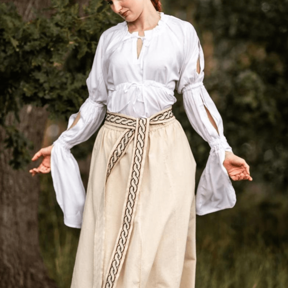 White Renaissance blouse with gathered, split long sleeves and waist lacing, paired with a beige skirt.