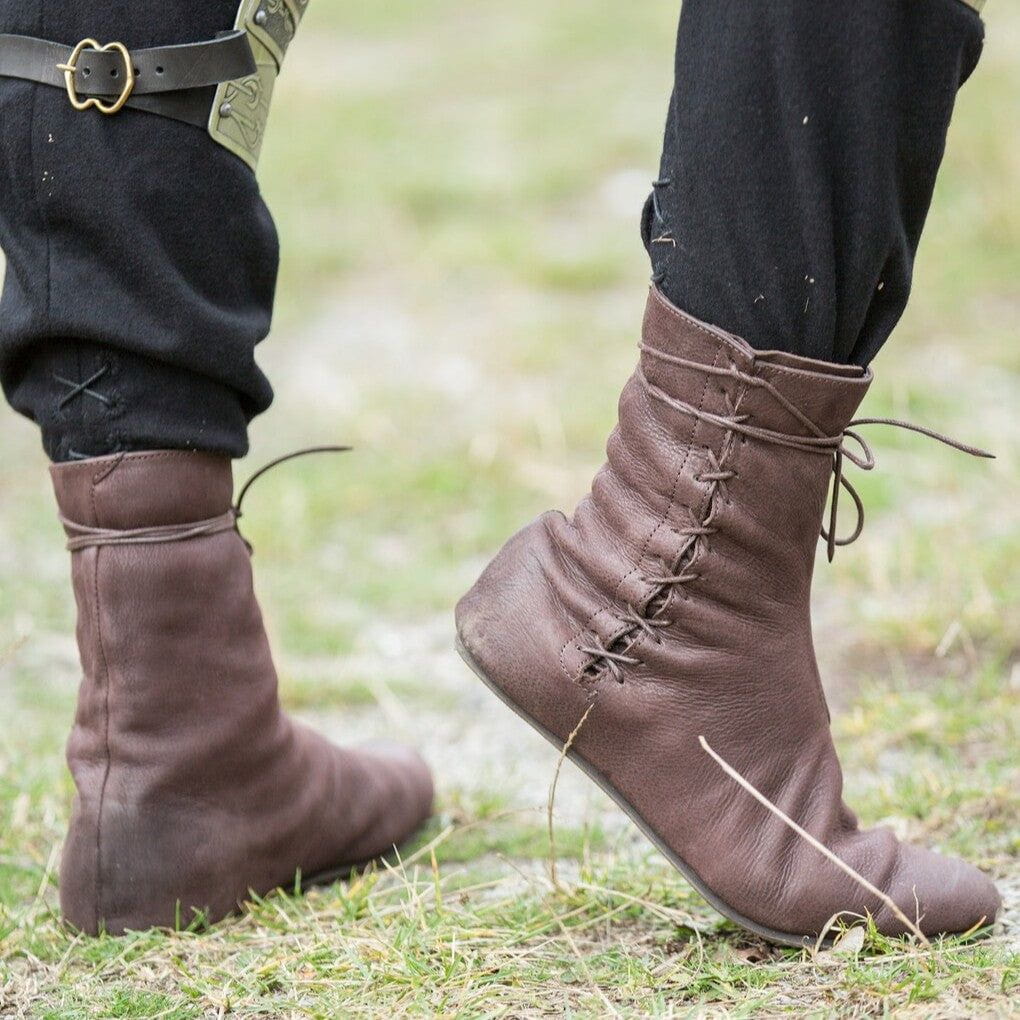 Side view of a brown lace-up medieval ankle boot