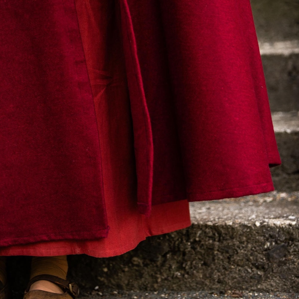 Back view of a red wool cloak showing the full length
