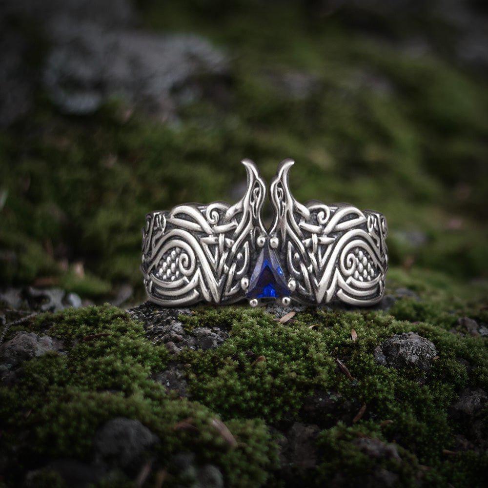 Sterling silver ring with two carved ravens flanking a blue gemstone